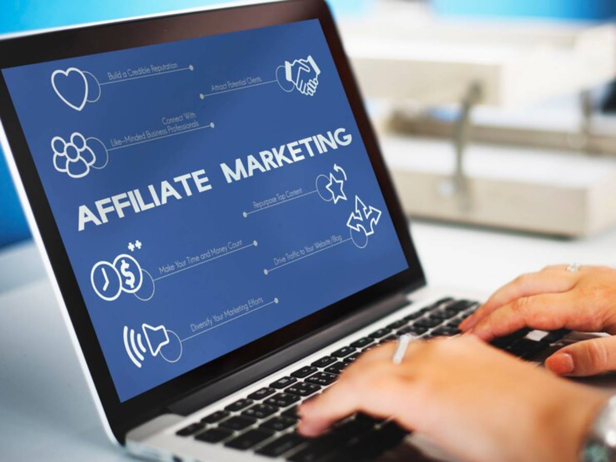 A person typing on a laptop displaying "Affiliate Marketing" with icons and text highlighting strategies for success in affiliate marketing.